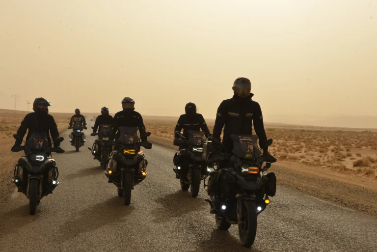 Motards du Tunisia Adventure Tour dans le désert au coucher du soleil